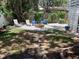 The backyard boasts stone walkway, a fire pit with chairs, and well-maintained landscaping at 401 Pennsylvania Ave, Crystal Beach, FL 34681