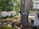 Landscaped backyard with stone pathway, white fence, and a 'Welcome' sign on the tree at 401 Pennsylvania Ave, Crystal Beach, FL 34681