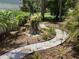 Landscaped backyard with small trees, grass, and a stone walking path at 401 Pennsylvania Ave, Crystal Beach, FL 34681