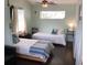 Comfortable bedroom with two beds, side tables, and hardwood floors, perfect for guests at 401 Pennsylvania Ave, Crystal Beach, FL 34681
