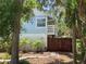 Charming two-story cottage featuring a light blue facade, fenced yard, and tropical landscaping at 401 Pennsylvania Ave, Crystal Beach, FL 34681