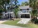 Charming home with a light blue exterior, white railings, and lush landscaping at 401 Pennsylvania Ave, Crystal Beach, FL 34681