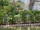 Tropical plants border the fence that surrounds the property at 401 Pennsylvania Ave, Crystal Beach, FL 34681