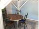 Enjoy outdoor dining on this charming patio complete with rustic table, chairs, and cozy string lights at 401 Pennsylvania Ave, Crystal Beach, FL 34681