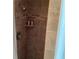 Shower stall with two shelves holding shampoo and other toiletries and brown tiled walls at 401 Pennsylvania Ave, Crystal Beach, FL 34681