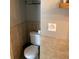Tight shot of a white toilet with brown tiled walls at 401 Pennsylvania Ave, Crystal Beach, FL 34681