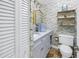 Charming half-bathroom with vanity, floral wallpaper, and storage shelf at 4202 Harbor House Dr # 24, Tampa, FL 33615