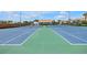 Community tennis court with green and blue playing surface and nearby seating at 4202 Harbor House Dr # 24, Tampa, FL 33615