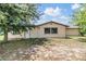 Backyard exterior showcasing a single-story house with a door, window, and partial lawn at 4228 Belle Isle Ct, New Port Richey, FL 34653