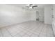 Bright bedroom with tiled floors, a ceiling fan, and an open doorway leading to an attached space at 4228 Belle Isle Ct, New Port Richey, FL 34653