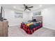 This cozy bedroom has carpet, a ceiling fan, and windows with treetop views at 4228 Belle Isle Ct, New Port Richey, FL 34653
