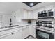 Modern kitchen featuring stainless steel appliances and white cabinetry at 4228 Belle Isle Ct, New Port Richey, FL 34653