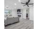 Cozy living room featuring wood-look flooring and a modern fireplace with large windows at 4228 Belle Isle Ct, New Port Richey, FL 34653