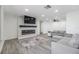 Bright living room features a modern fireplace and comfortable gray sectional seating at 4228 Belle Isle Ct, New Port Richey, FL 34653
