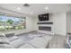 Contemporary living room with light gray furniture, laminate flooring, and fireplace with a large window at 4228 Belle Isle Ct, New Port Richey, FL 34653