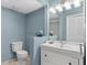 Charming bathroom with blue walls, a classic vanity, and a decorative mirror, creating a serene and inviting atmosphere at 4777 Duhme Rd # 1D, St Petersburg, FL 33708
