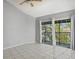Cozy bedroom with ample natural light from the sliding glass door, tile flooring, and ceiling fan for comfortable living at 4777 Duhme Rd # 1D, St Petersburg, FL 33708