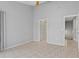 Neutral bedroom with tile floors, ceiling fan, closet, and a doorway leading to another room, creating a versatile space at 4777 Duhme Rd # 1D, St Petersburg, FL 33708