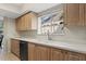 Bright kitchen features light wood cabinets, speckled countertops, stainless dishwasher, and double stainless sink at 4777 Duhme Rd # 1D, St Petersburg, FL 33708