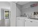 Convenient laundry room with modern washer and dryer, and additional storage space; adjacent to an open room with balcony access at 4777 Duhme Rd # 1D, St Petersburg, FL 33708