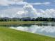 Picturesque view of the pond, reflecting the sky, from the home's backyard, with neighboring houses at 5082 Inshore Landings Dr, Apollo Beach, FL 33572