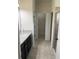 Bathroom with granite countertop, dark cabinets, tiled floors, and walk-in shower at 5082 Inshore Landings Dr, Apollo Beach, FL 33572