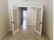 Bedroom with glass paneled doors, neutral walls and tile flooring at 5082 Inshore Landings Dr, Apollo Beach, FL 33572