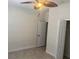 A serene bedroom showcasing neutral walls, tile floors, a ceiling fan, and a closet for easy storage at 5082 Inshore Landings Dr, Apollo Beach, FL 33572