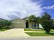 Charming single-Gathering home with a two-car garage, palm trees, and a well-manicured lawn at 5082 Inshore Landings Dr, Apollo Beach, FL 33572