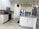 Modern kitchen featuring an island, stainless steel appliances, granite countertops, and tiled flooring at 5082 Inshore Landings Dr, Apollo Beach, FL 33572