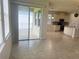 Bright living room with tile floors leading to a covered patio and modern kitchen at 5082 Inshore Landings Dr, Apollo Beach, FL 33572