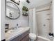 Bathroom features round mirror, modern vanity, neutral tiling and shower at 5236 Madison St, New Port Richey, FL 34652