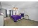 A well-lit bedroom featuring a comfortable bed with a plush purple comforter and matching bedside tables at 5236 Madison St, New Port Richey, FL 34652