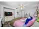 Bright bedroom featuring a ceiling fan, dresser with TV, and vanity area with good natural light at 5236 Madison St, New Port Richey, FL 34652