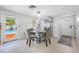 Bright dining room featuring modern glass table, seating for four, and a view of the pool at 5236 Madison St, New Port Richey, FL 34652