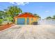 Detached garage with a blue door and ample parking space, featuring a well-maintained exterior at 5236 Madison St, New Port Richey, FL 34652