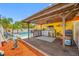Covered outdoor kitchen with a grill, bar area, and deck overlooking the backyard pool at 5236 Madison St, New Port Richey, FL 34652
