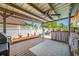 Outdoor covered patio with wooden deck, built in bar, grill and white lattice fence; perfect for entertaining at 5236 Madison St, New Port Richey, FL 34652
