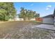 Spacious, partially grassy backyard featuring mature trees and a wooden shed at 5396 Berrien Ave, Spring Hill, FL 34608