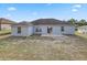 Exterior view of the home's backyard features a partially grassy yard, and a gray exterior at 5396 Berrien Ave, Spring Hill, FL 34608