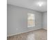 Light-filled bedroom features neutral walls and wood-look floors and a window with blinds at 5396 Berrien Ave, Spring Hill, FL 34608