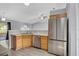 Kitchen with stainless steel appliances, wood cabinets, breakfast bar overlooking the living area at 5396 Berrien Ave, Spring Hill, FL 34608
