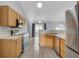 Modern kitchen with wood cabinetry, stainless steel appliances, and tile flooring at 5396 Berrien Ave, Spring Hill, FL 34608