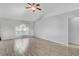 Bright living room featuring wood-look tile flooring, a ceiling fan, and a large window at 5396 Berrien Ave, Spring Hill, FL 34608