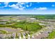 An aerial view of several homes in a neighborhood near lush greenery, ponds, and a bright blue sky at 5430 Thistle Field Ct, Wesley Chapel, FL 33545
