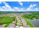 Beautiful aerial view of homes in a friendly neighborhood, near ponds, lush trees, and a bright blue sky at 5430 Thistle Field Ct, Wesley Chapel, FL 33545