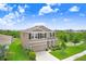 Aerial view of a two-story home with a well-manicured lawn, inviting entrance, and attached two car garage at 5430 Thistle Field Ct, Wesley Chapel, FL 33545