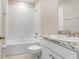 Well-lit bathroom with a tub-shower, white vanity, and granite countertop for a clean modern look at 5430 Thistle Field Ct, Wesley Chapel, FL 33545