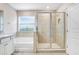 Bright bathroom featuring a soaking tub, glass-enclosed shower, and a window providing natural light at 5430 Thistle Field Ct, Wesley Chapel, FL 33545