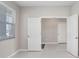 A modern bedroom with white tiled floors and a bright window view at 5430 Thistle Field Ct, Wesley Chapel, FL 33545